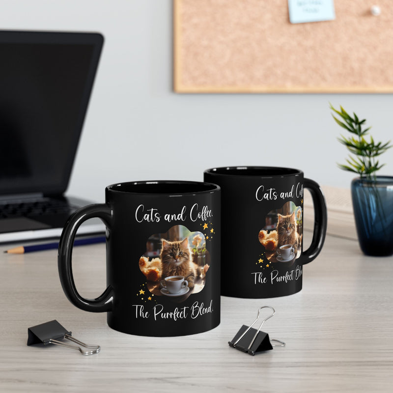 Two black mugs with an orange cat and "Cats and Coffee: The Purrfect Blend" design, displayed on an office desk. Fun coffee mugs for cat lovers, available in 11oz and 15oz sizes