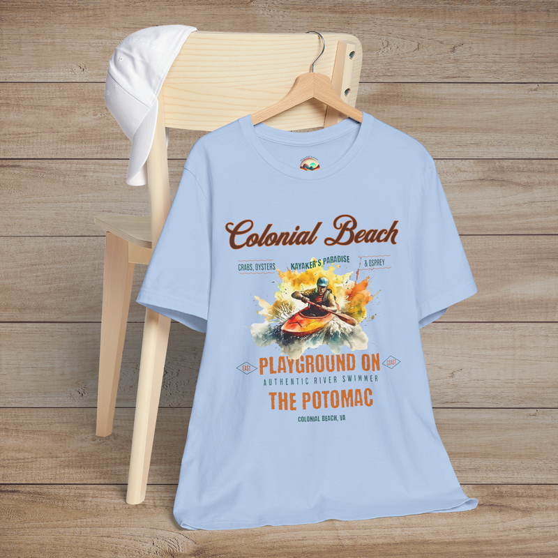 Colonial Beach Premium T-Shirt Playground on the Potomac design neatly arranged on a baby blue t-shirt, hanging on a wooden chair with a casual white cap