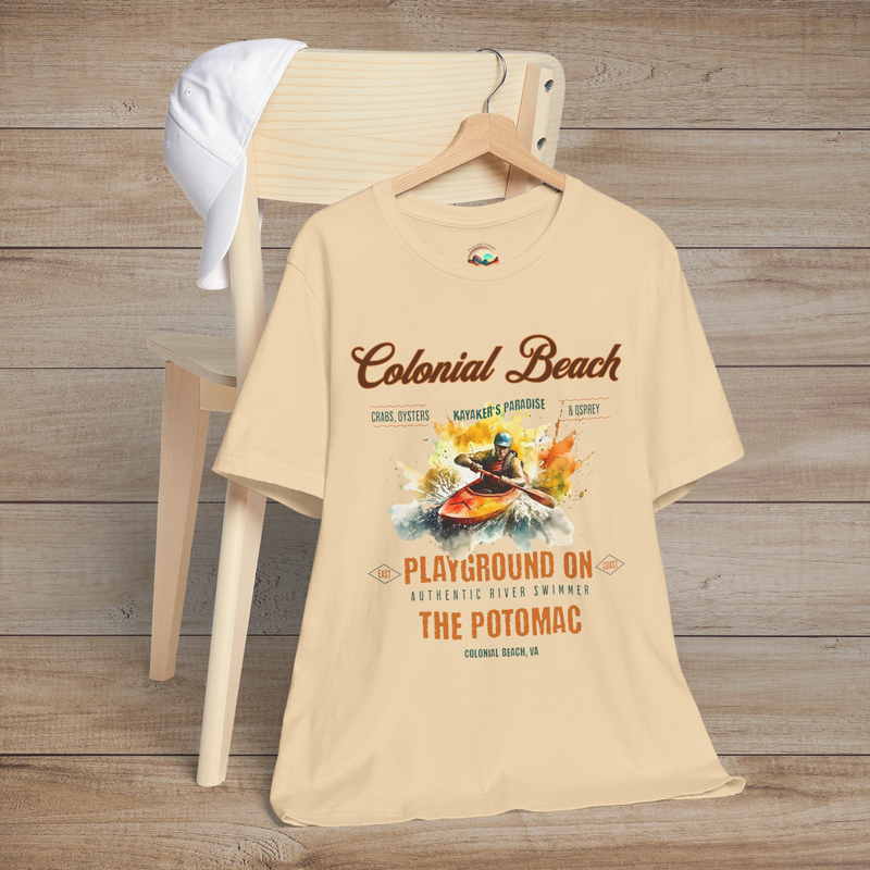 Colonial Beach Premium T-Shirt Playground on the Potomac design printed on a soft cream t-shirt, styled flat on a rustic chair with a cap, evoking beach adventure spirit