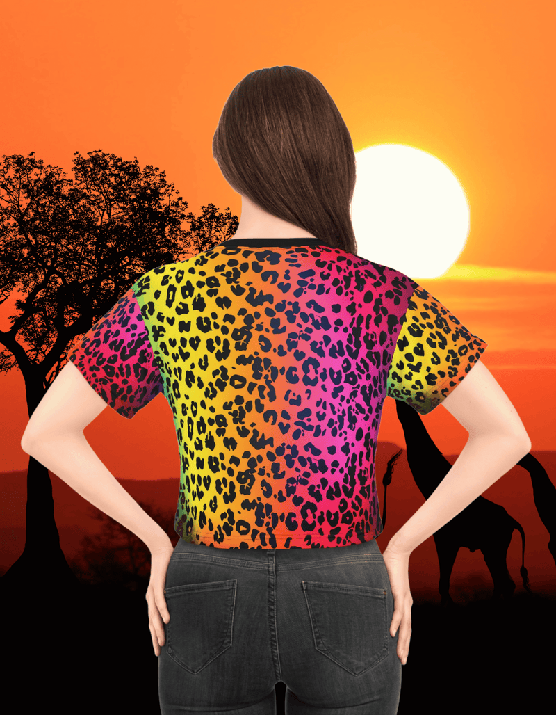 Back view of a woman showing The Colorful Leopard Crop Top featuring a vibrant rainbow leopard print pattern, styled in front of a sunset savanna background
