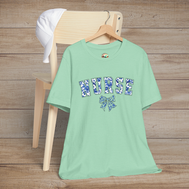 Heather mint green nurse t-shirt with delicate blue floral 'NURSE' lettering and a bow design, ideal for a soft yet strong professional look