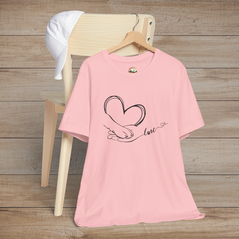 Pink t-shirt featuring clean black line art of a heart created by a human hand and a paw, connected by love script
