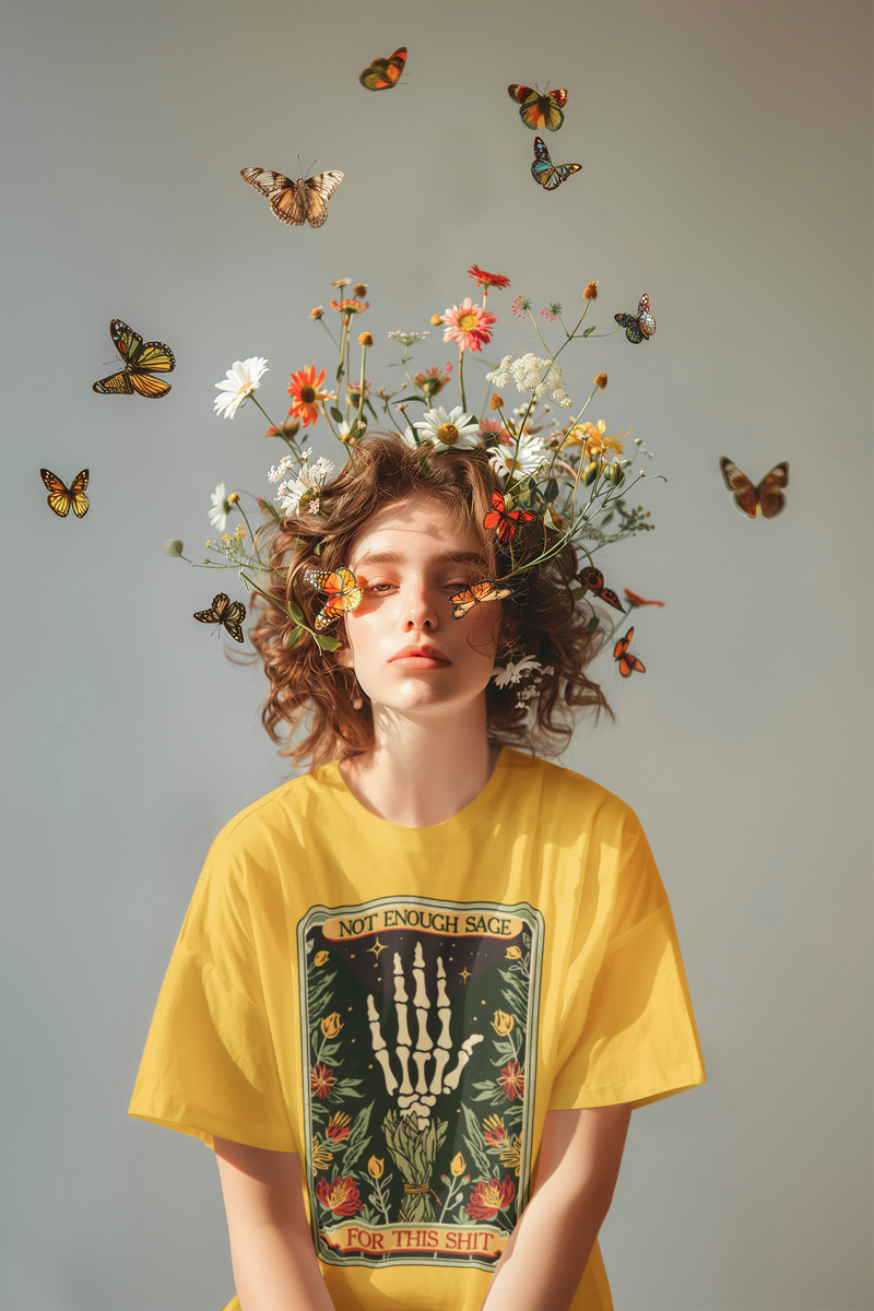 Artistic portrait of a female model wearing Heather Yellow Gold Not Enough Sage for This Sh*t T-Shirt, surrounded by flowers and butterflies, emphasizing boho aesthetics
