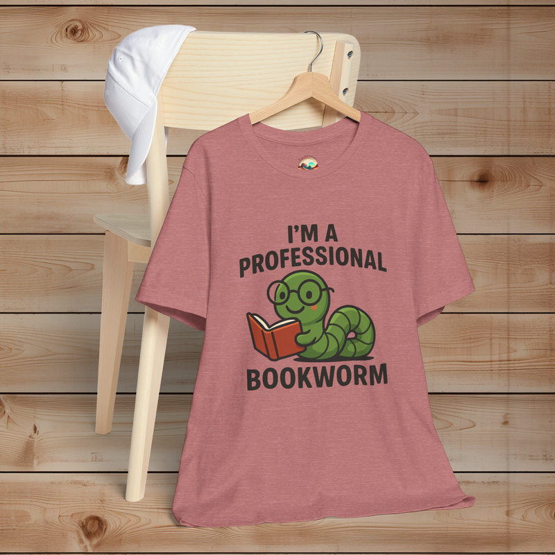 Heather mauve t-shirt with a graphic and text 'I'm a Professional Bookworm' on a wooden chair.