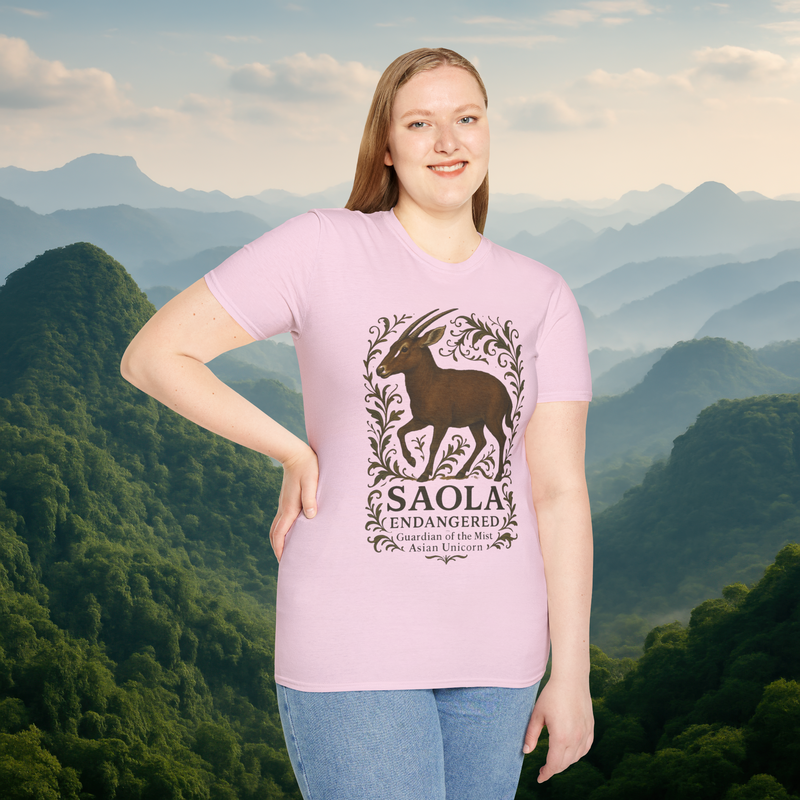 Woman wearing the Saola Endangered Asian Unicorn T-Shirt in Light Pink – premium cotton t-shirt featuring endangered Saola artwork, with a misty mountain landscape in the background