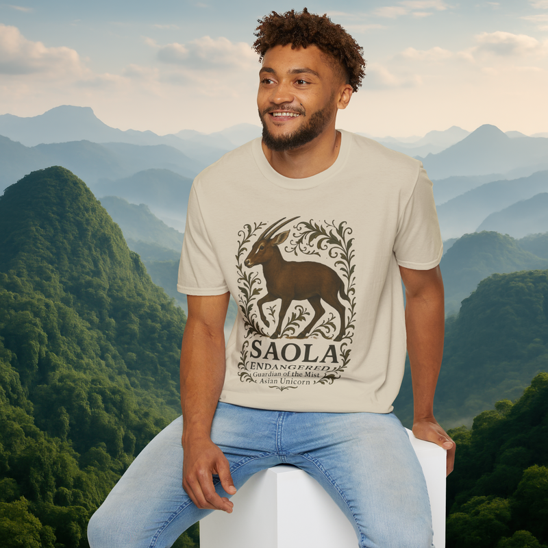 Man modeling the Saola Endangered Asian Unicorn T-Shirt in Sand – premium breathable t-shirt with detailed Saola and botanical artwork, photographed in a serene misty mountain landscape