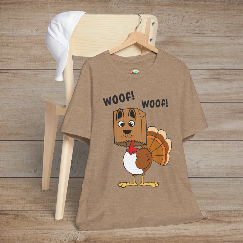 Cartoon turkey pretending to be a dog with “Woof! Woof!” text on heather tan holiday tee