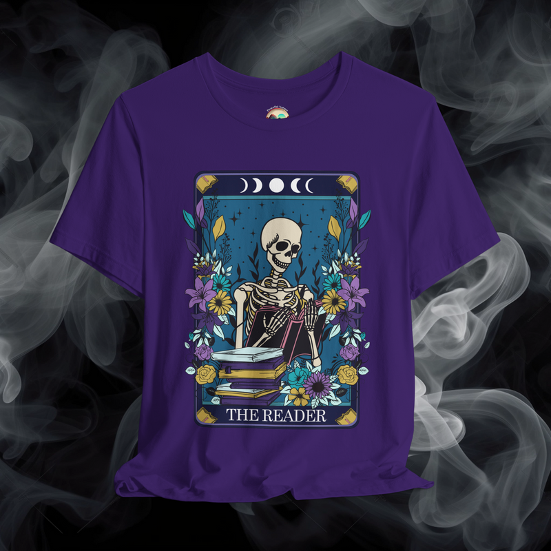 The Reader T-Shirt with a Bohemian tarot card design of a skeleton engrossed in reading, adorned with celestial symbols on purple fabric