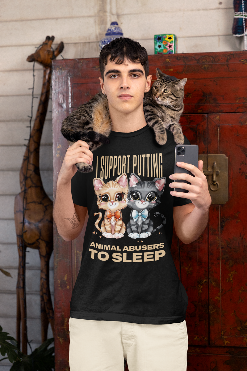 Man wearing a black t-shirt with cat graphics and animal advocacy text, holding a phone, with a cat on his shoulder.