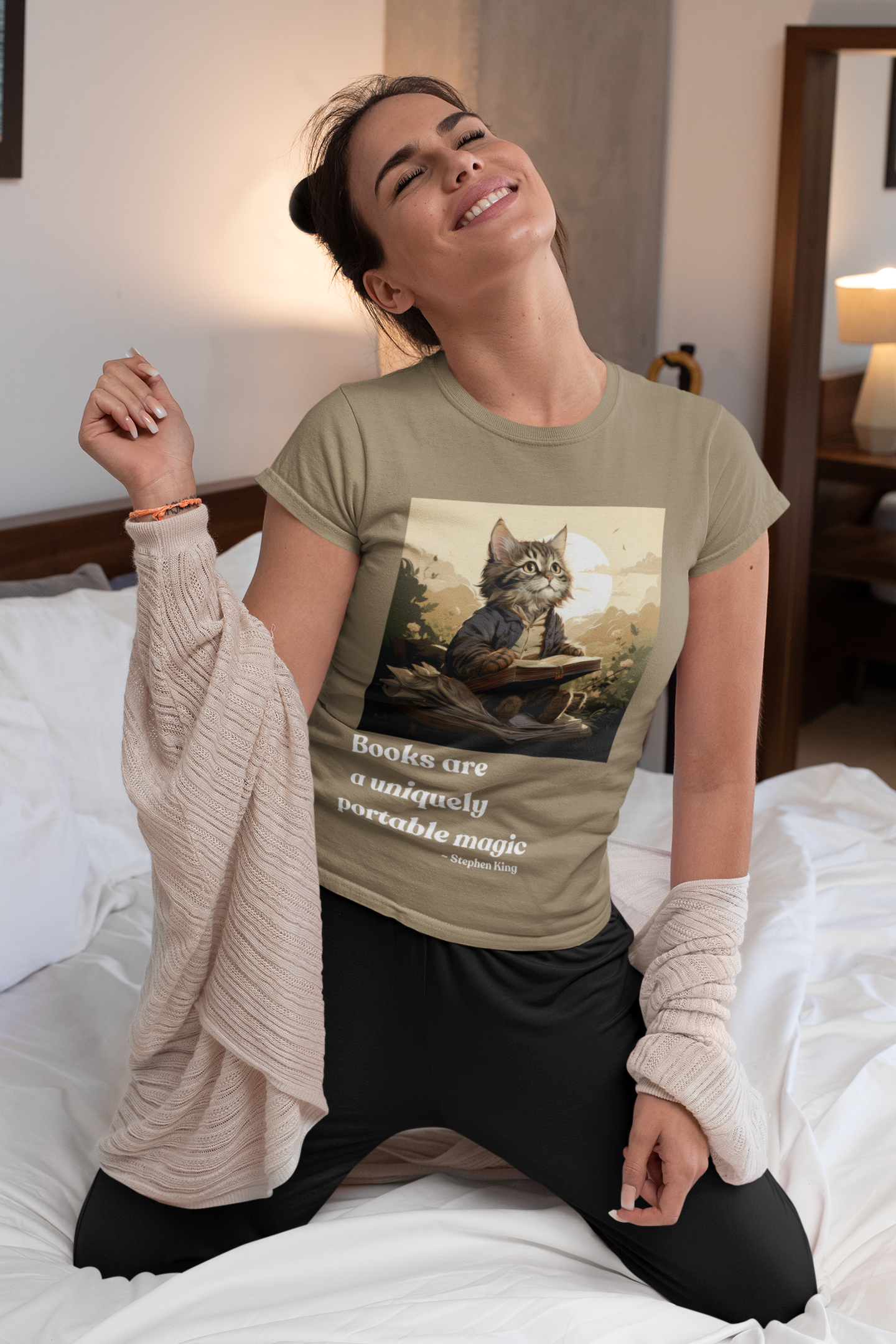 Woman smiling while wearing the Books Are a Uniquely Portable Magic cat t-shirt in heather olive
