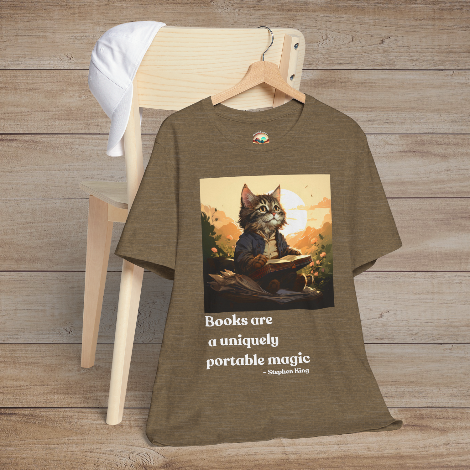Books Are a Uniquely Portable Magic cat t-shirt in heather olive displayed on a wooden chair