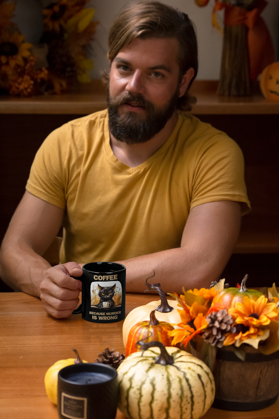 Man  displaying 11 oz black mug, left view, with angry cat design and funny "Coffee Because Murder Is Wrong" saying