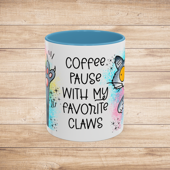 Front view of the 11 oz Coffee Pause with My Favorite Claws Mug with cheerful light blue interior trim, featuring whimsical cartoon art of a playful cat and paw, alongside the humorous quote 'Coffee pause with my favorite claws.' Ideal mug for cat lovers
