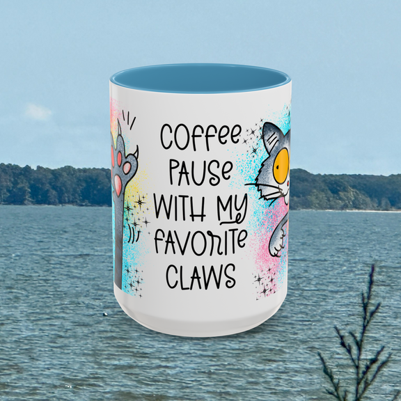 Front view of the larger 15 oz Coffee Pause with My Favorite Claws Mug with attractive light blue interior trim, displaying charming illustrations of a cat paw and playful feline face paired with the delightful phrase 'Coffee pause with my favorite claws.' A great gift for cat lovers