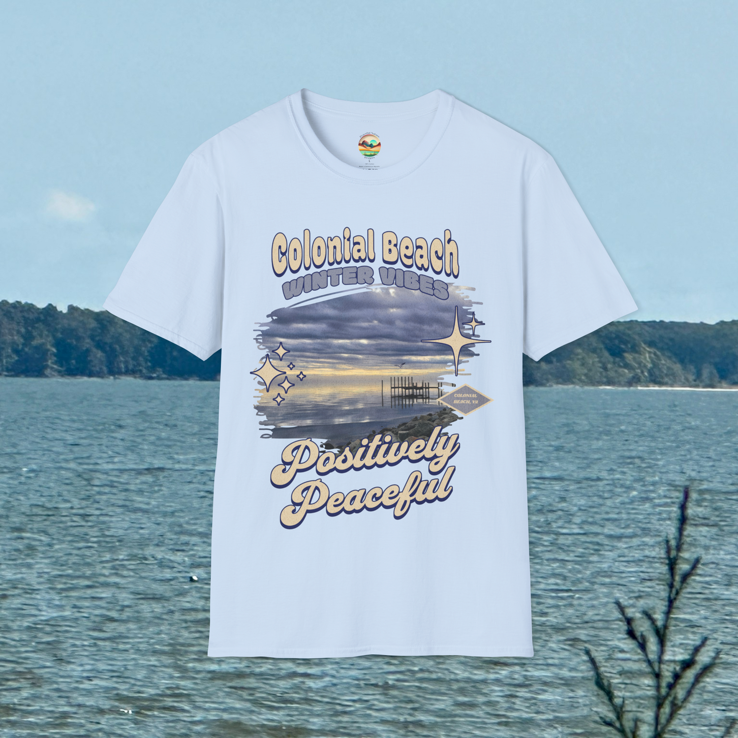Colonial Beach Winter Vibes Soft Fit T-Shirt in Light Blue, displayed hanging in front of water view