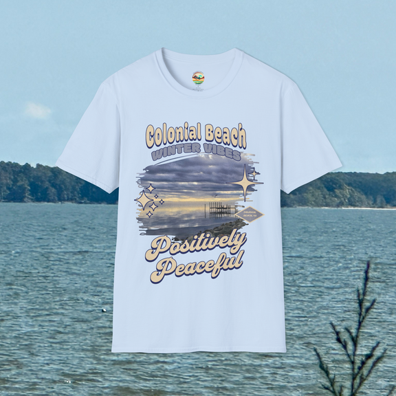 Colonial Beach Winter Vibes Soft Fit T-Shirt in Light Blue, displayed hanging in front of water view