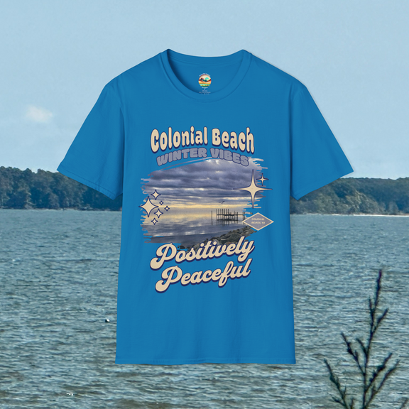 Colonial Beach Winter Vibes Soft Fit T-Shirt in Sapphire Blue, displayed hanging by scenic water view