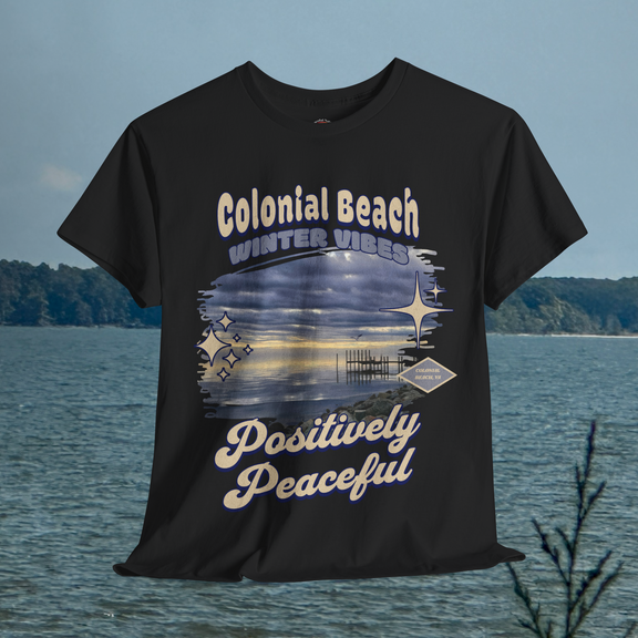 Colonial Beach Winter Vibes black t-shirt hanging in front of the ocean background