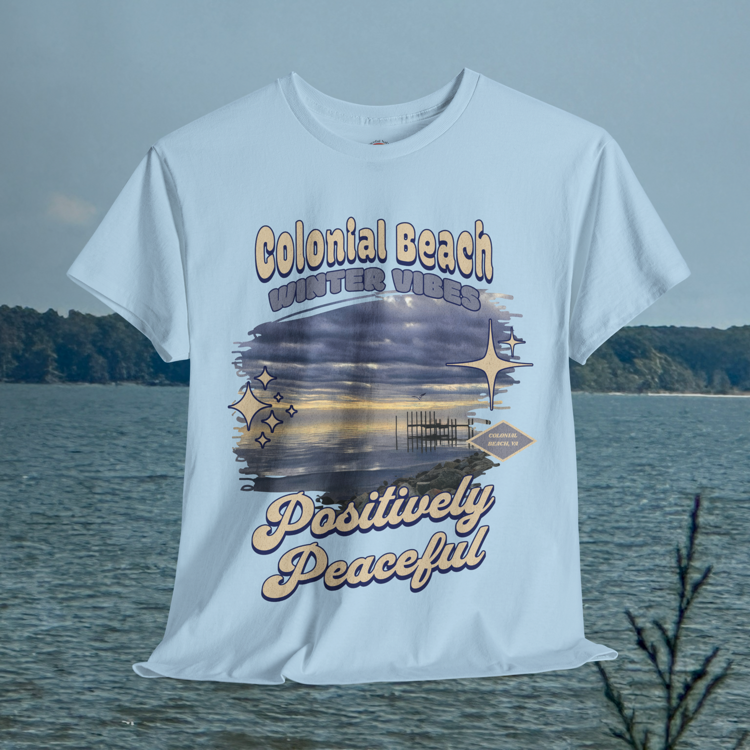 Colonial Beach Winter Vibes light blue t-shirt hanging with calm ocean backdrop