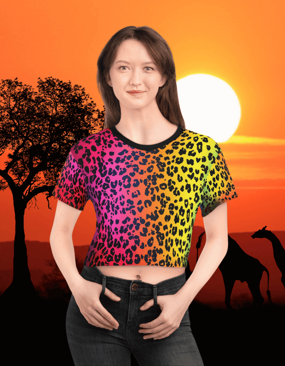 Front view of a woman wearing The Colorful Leopard Crop Top with a bold, multicolor leopard print design against a vibrant sunset savanna background
