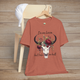 Flat lay of "Do No Harm But Take No Bull" t-shirt in heather clay with bull skull and floral crown
