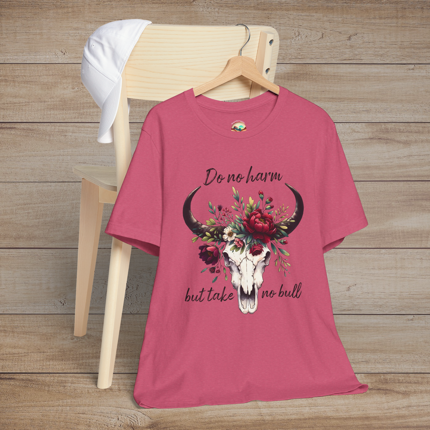Flat lay of "Do No Harm But Take No Bull" t-shirt in heather raspberry with bull skull and floral crown