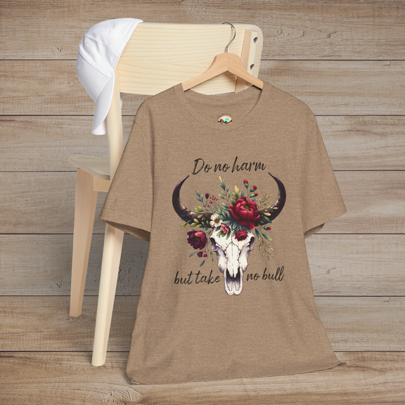 Flat lay of "Do No Harm But Take No Bull" t-shirt in heather tan with bull skull and floral crown