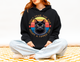 Woman wearing a black “Don’t Fear the Ear – Adopt a Tipped Cat” hoodie featuring a retro black cat design.
