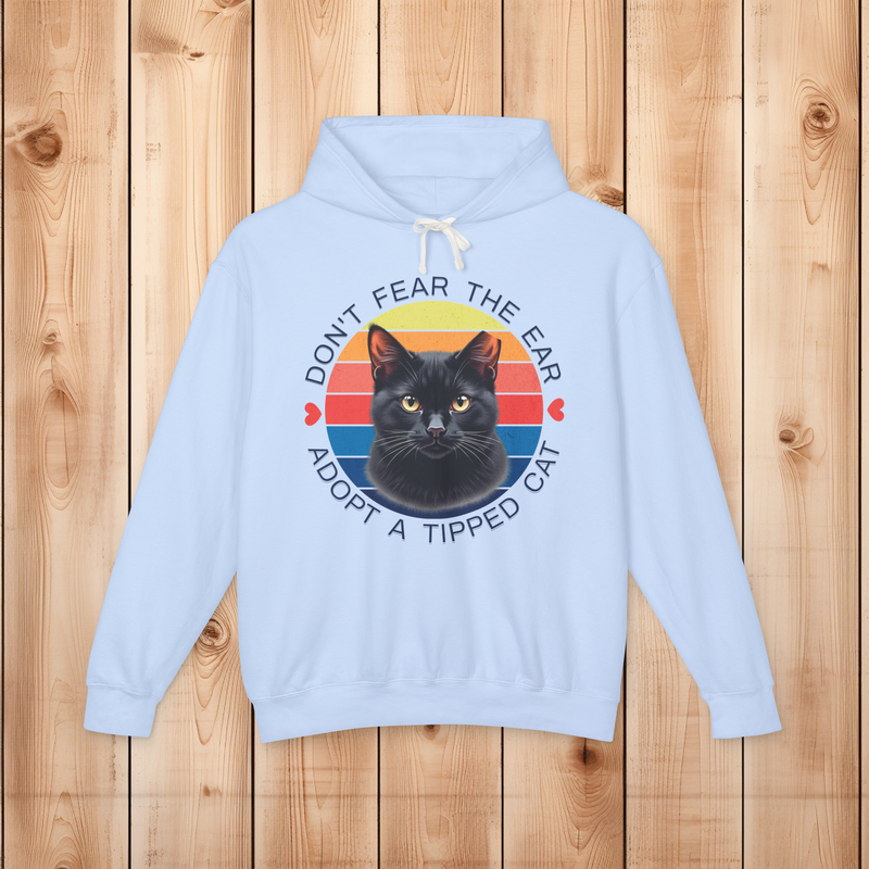 Flatlay mockup of a hydrangea blue “Don’t Fear the Ear – Adopt a Tipped Cat” hoodie with black cat artwork.