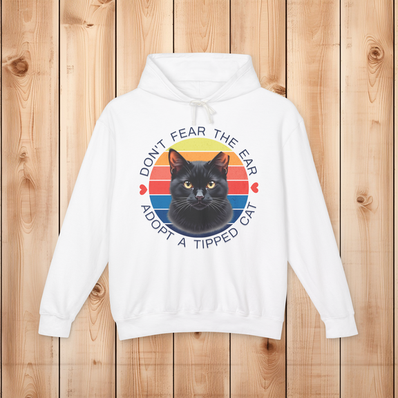 Flatlay of a white “Don’t Fear the Ear – Adopt a Tipped Cat” hoodie featuring a colorful retro black cat graphic.