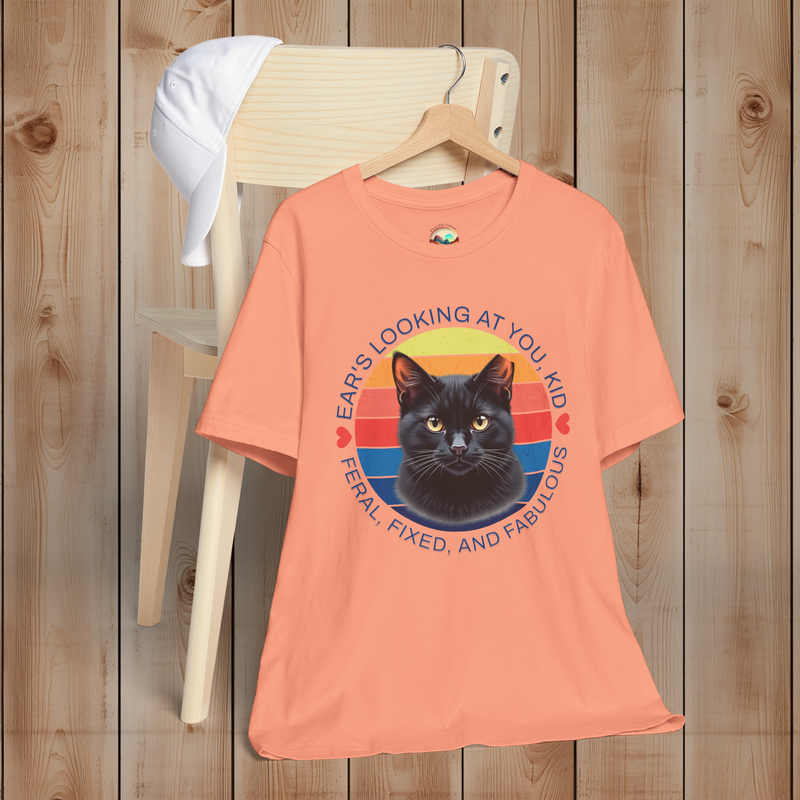 Sunset peach Ear’s Looking at You Kid TNR cat shirt with retro ear-tipped black cat design, Bella Canvas 3001 flatlay.