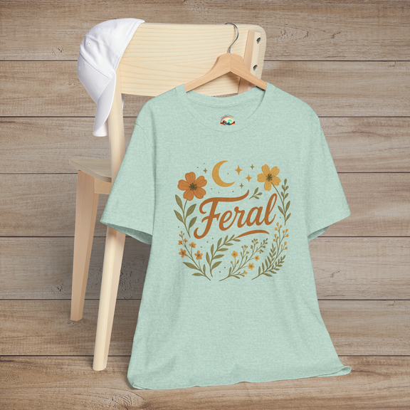 Feral t-shirt in Heather Prism Mint with floral and moon design in elegant calligraphy, displayed on a chair with a cap