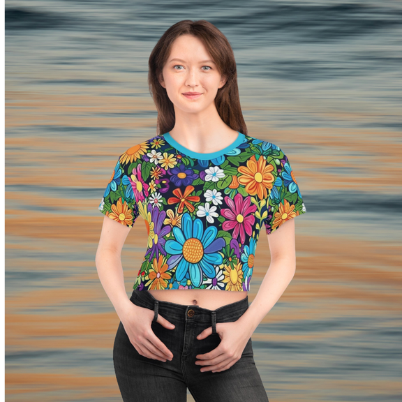 Front view of a smiling woman wearing a colorful cropped t-shirt with a bright floral pattern, solid blue neckline, and eye-catching flower illustrations in a cheerful, artistic style