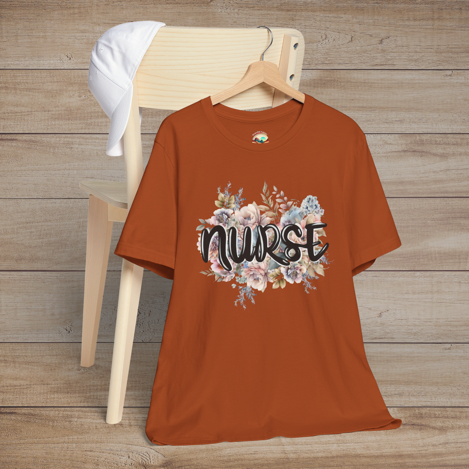 Autumn-colored Nurse Floral Premium Fit T-Shirt displayed on hanger, featuring elegant pastel flowers and black script lettering