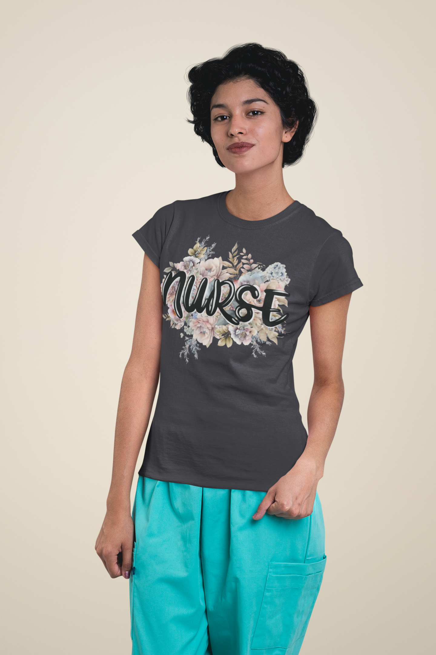 Confident woman in medical scrubs modeling the dark grey Nurse Floral Premium Fit T-Shirt, showing off its pastel floral design and elegant lettering