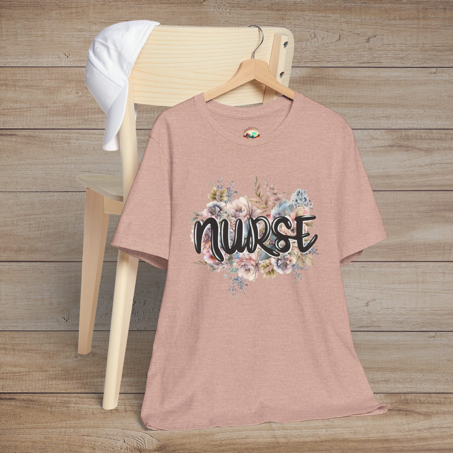 Heather prism peach Nurse Floral Premium Fit T-Shirt displayed beautifully on hanger, adorned with gentle pastel florals and scripted "Nurse"