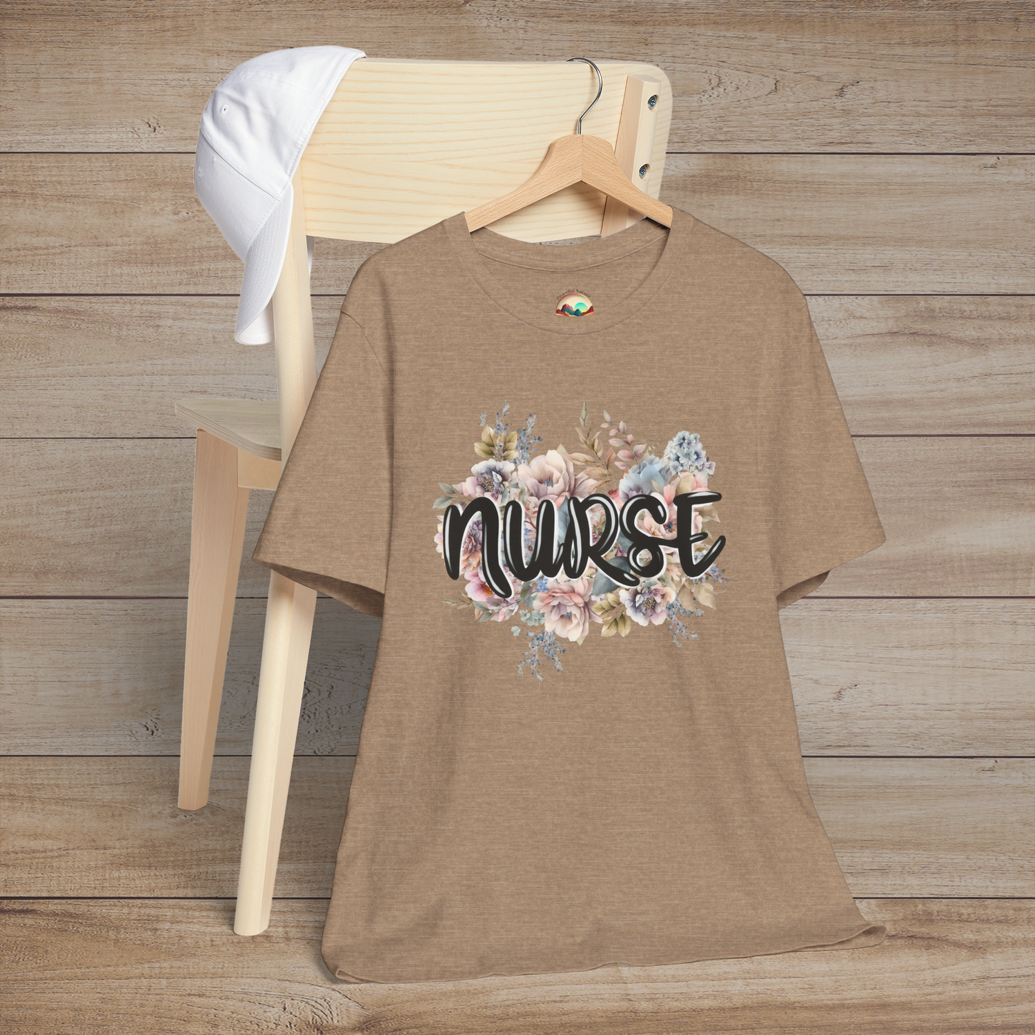 Heather tan Nurse Floral Premium Fit T-Shirt presented on hanger, showcasing pastel floral pattern and bold, elegant lettering