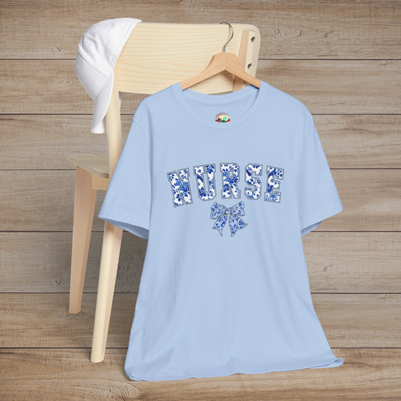 Light blue floral nurse t-shirt draped over a chair, showcasing the word 'NURSE' in bold flower-filled letters and a coordinating bow beneath