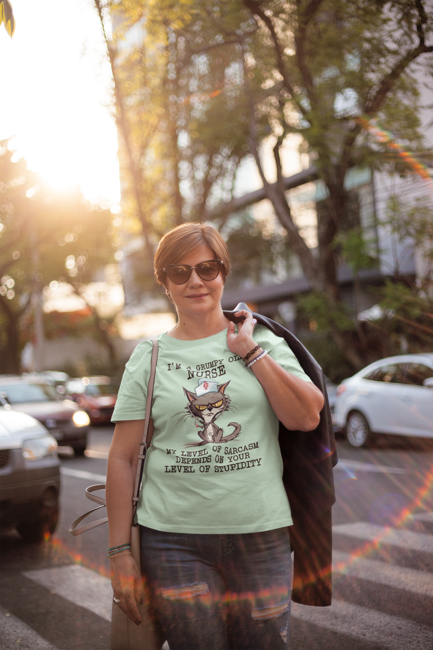 Woman in sunglasses outdoors wearing the Funny Nurse T-Shirt with sarcastic cat graphic and quote, premium mint green cotton fabric