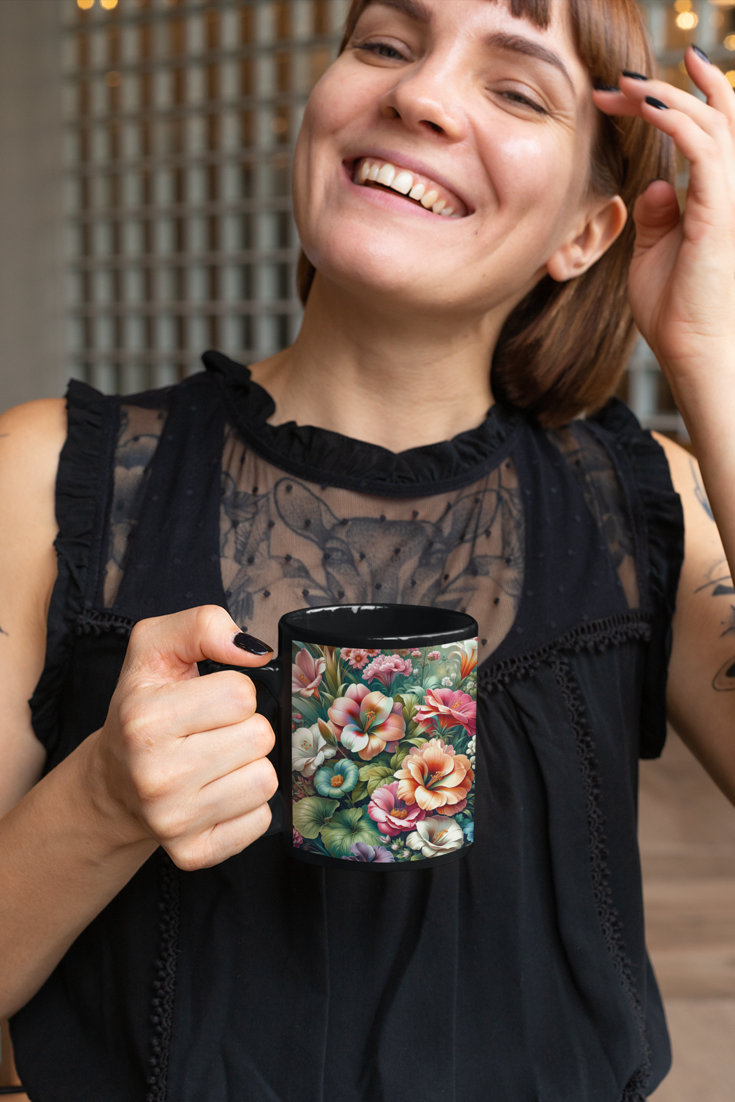 Smiling woman in a black dress holding an 11 oz floral coffee mug with a colorful garden of tropical flowers and lush green foliage