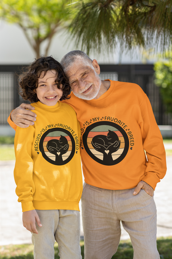 Two people wearing the Gildan 18000 Rescued Is My Favorite Breed crewneck sweatshirt in gold and safety orange