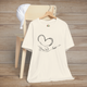 Natural color t-shirt with simple and elegant black line drawing of a hand, paw, heart, and flowing love script