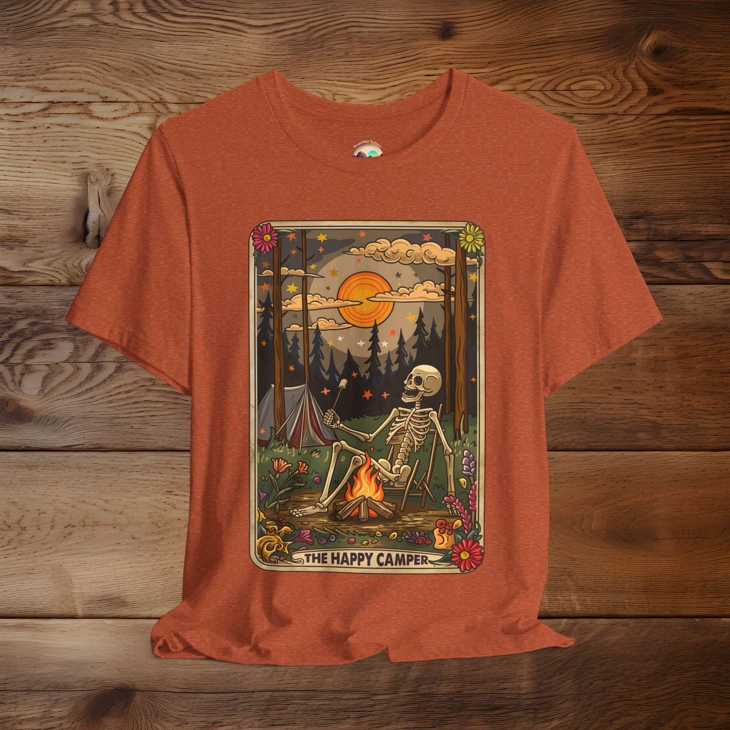 Heather Autumn Happy Camper Tarot T-Shirt showing a skeleton by a campfire, with a retro tarot card style