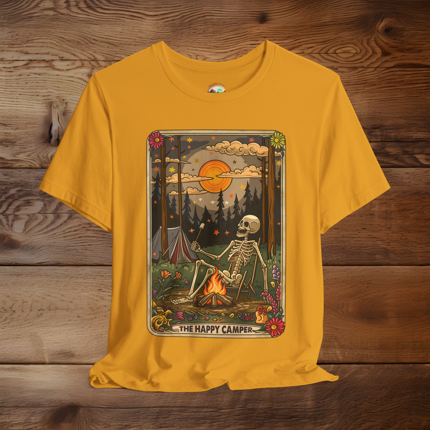 Mustard Yellow Happy Camper Tarot T-Shirt featuring a playful skeleton camping illustration with vibrant floral accents