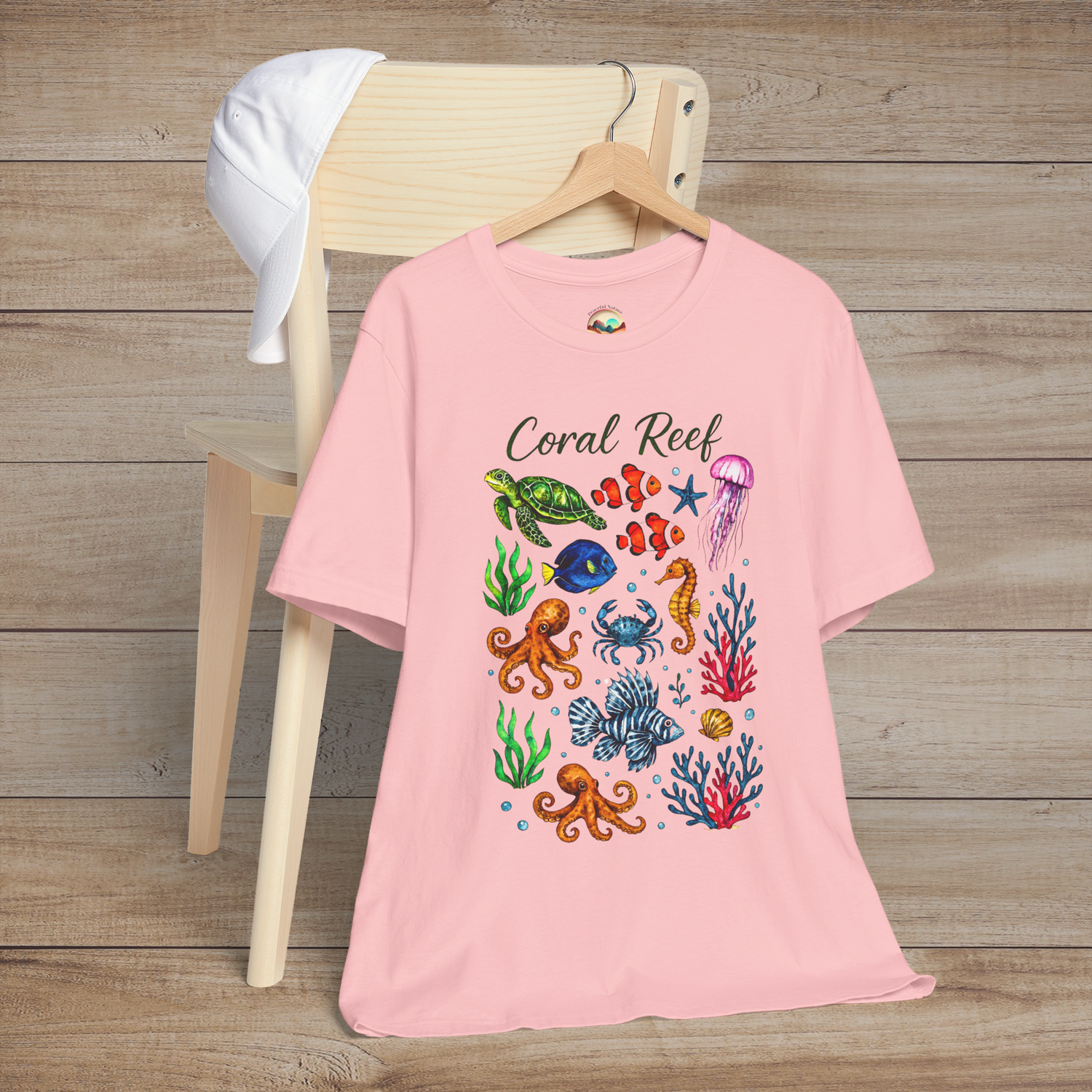 Coral Reef shirt in soft pink showing playful marine animals and coral