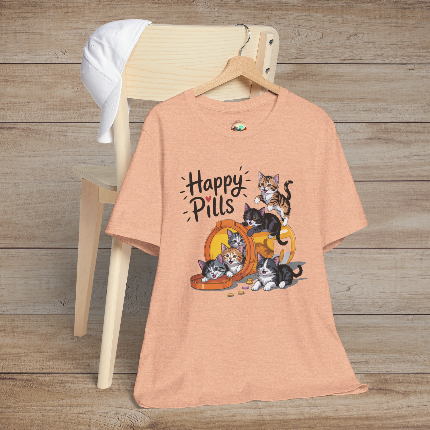 Happy Pills kitten t-shirt on heather peach fabric with cute cartoon kittens playing around an orange pill bottle