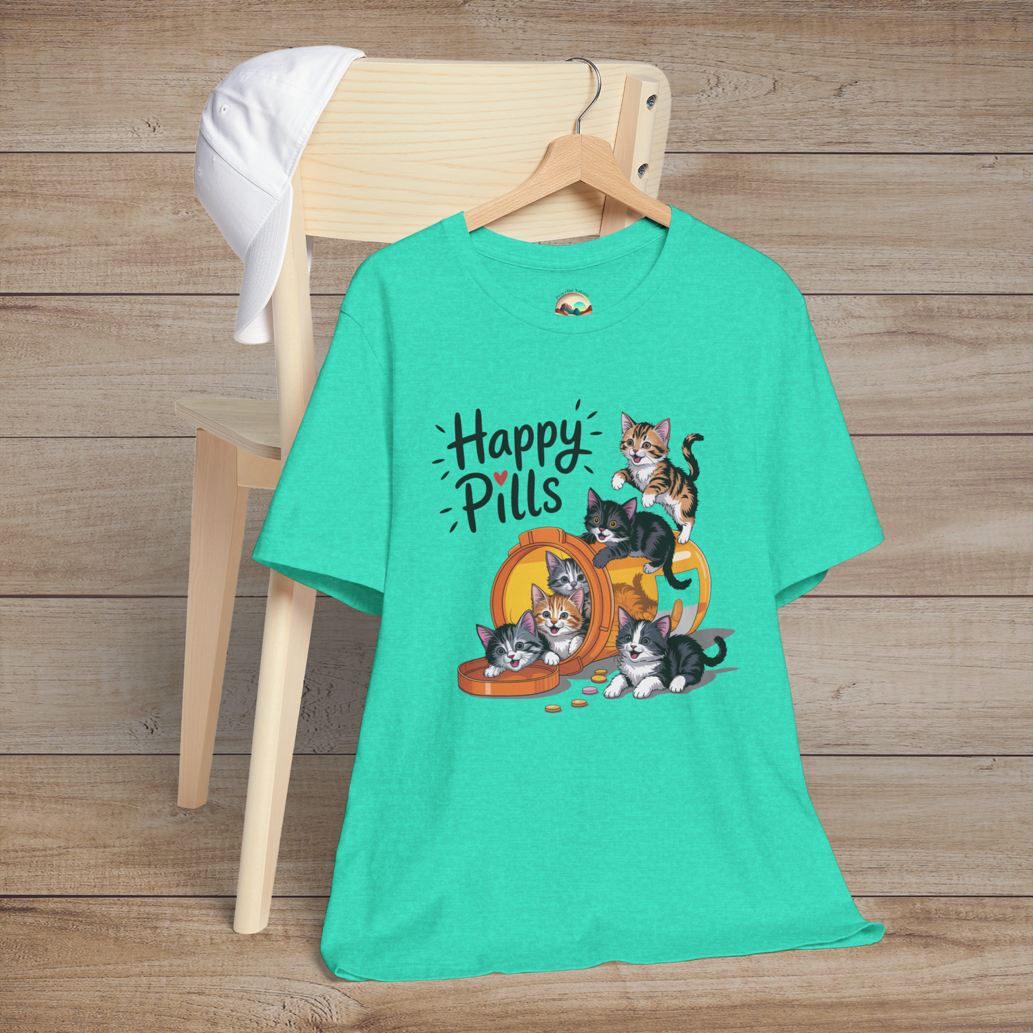 Happy Pills t-shirt in heather sea green with cheerful kittens spilling out of a labeled pill bottle