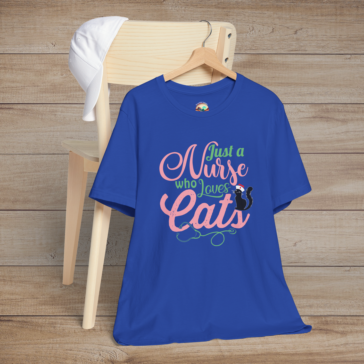 Royal blue t-shirt featuring stylish pink and green lettering Just a Nurse Who Loves Cats with a black cat wearing a nurse hat