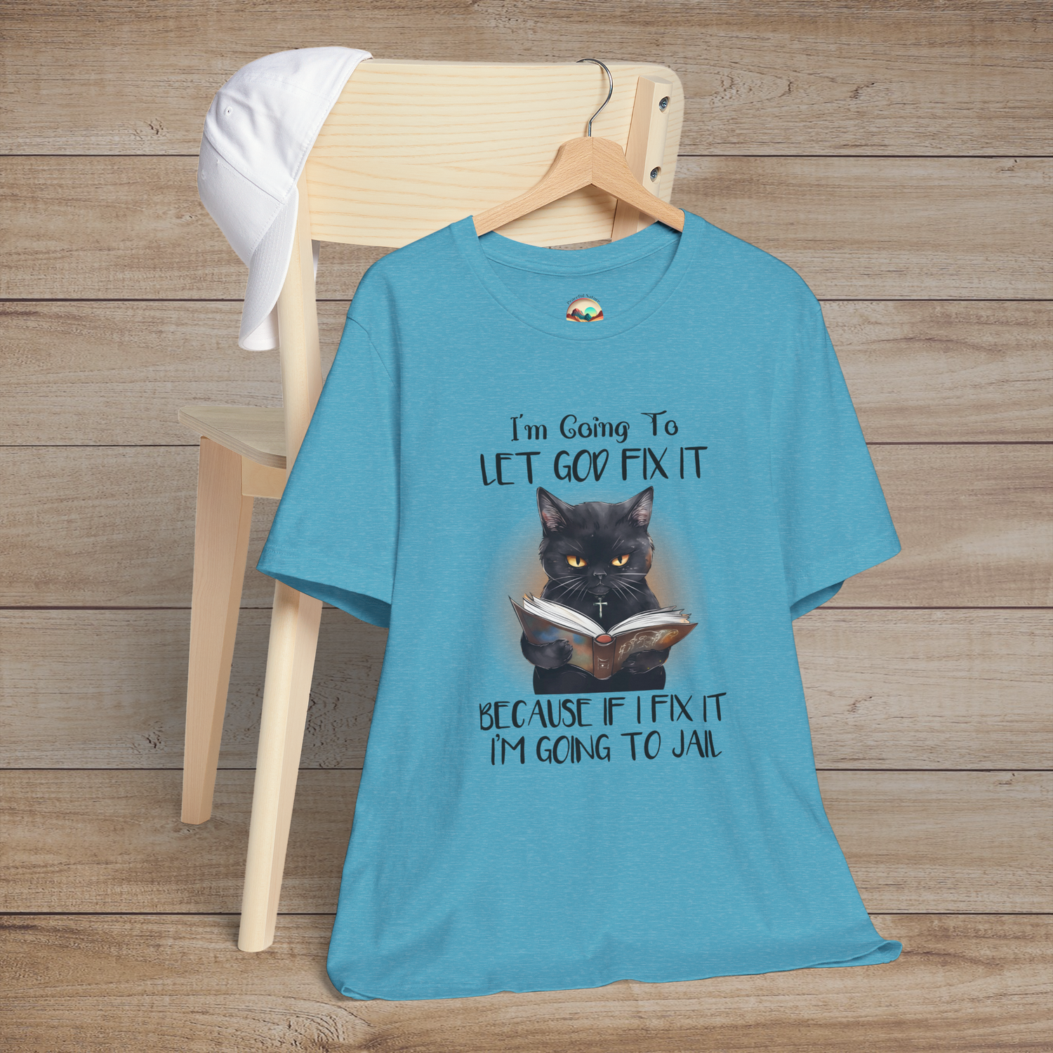 Heather aqua Let God Fix It T-Shirt showing a black cat wearing a cross and reading a book with funny religious humor