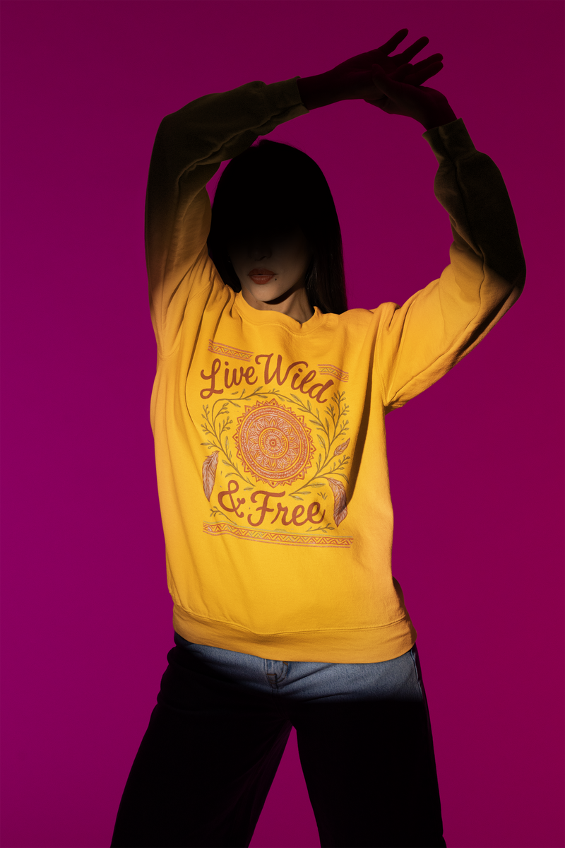 Model wearing a gold Live Wild & Free boho mandala sweatshirt under dramatic studio lighting